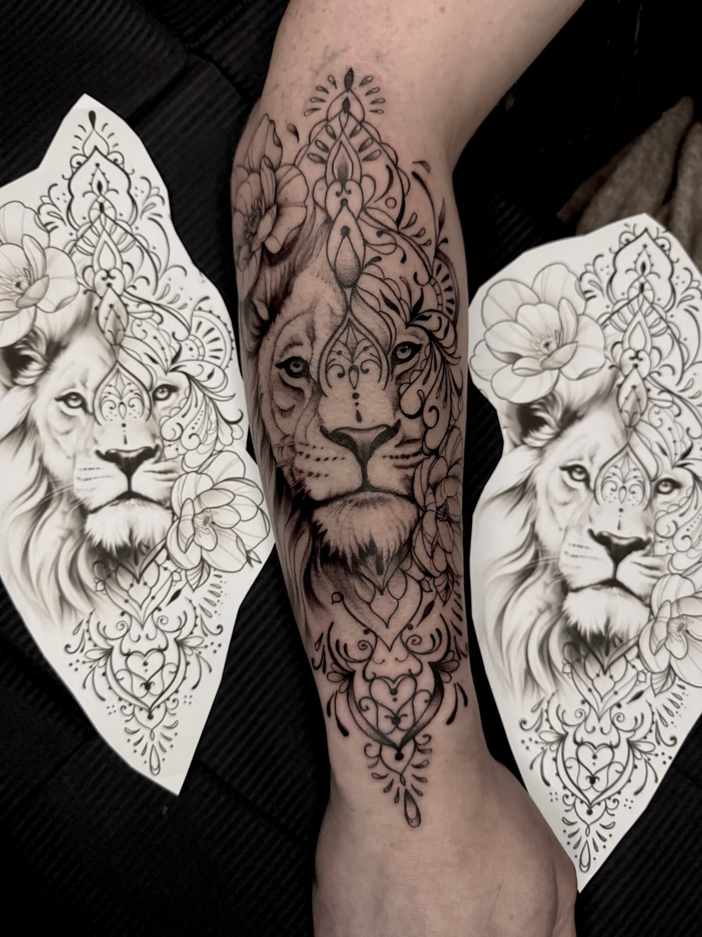 Löwe mit Mandala-Ornamenten und Blüten am Unterarm