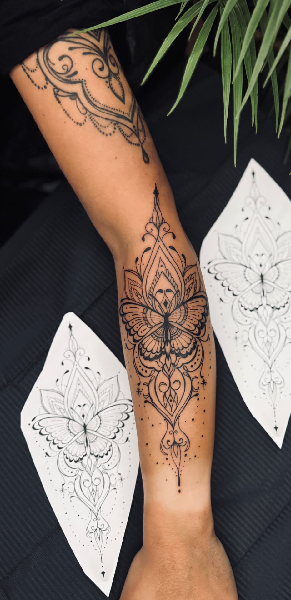 Ornamentales Mandala mit Schmetterling und Lotus am Unterarm