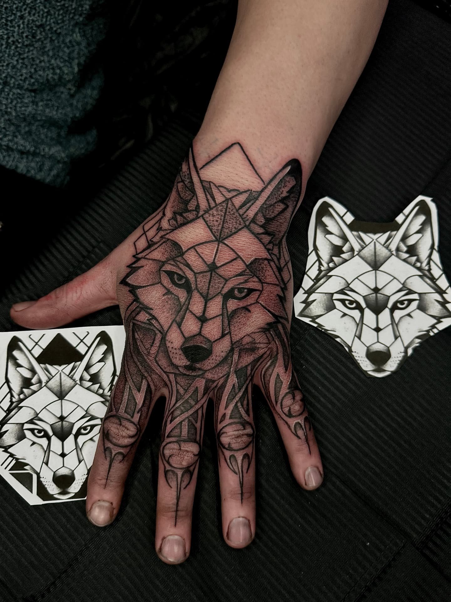 Geometrischer Wolf auf der Hand mit Finger-Ornamenten