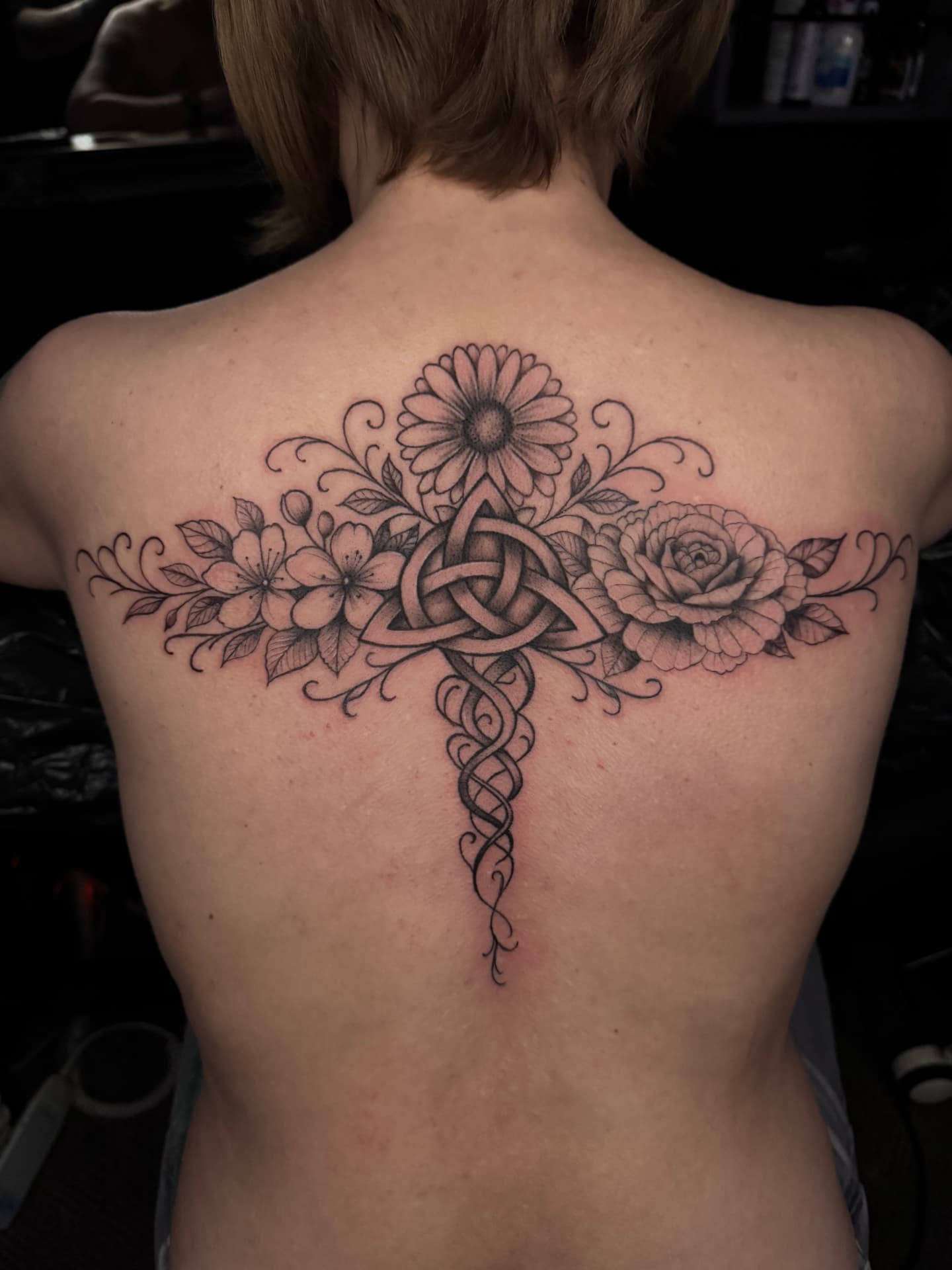 Filigranes Fineline Rücken-Tattoo mit keltischem Knoten, Sonnenblume und Rose