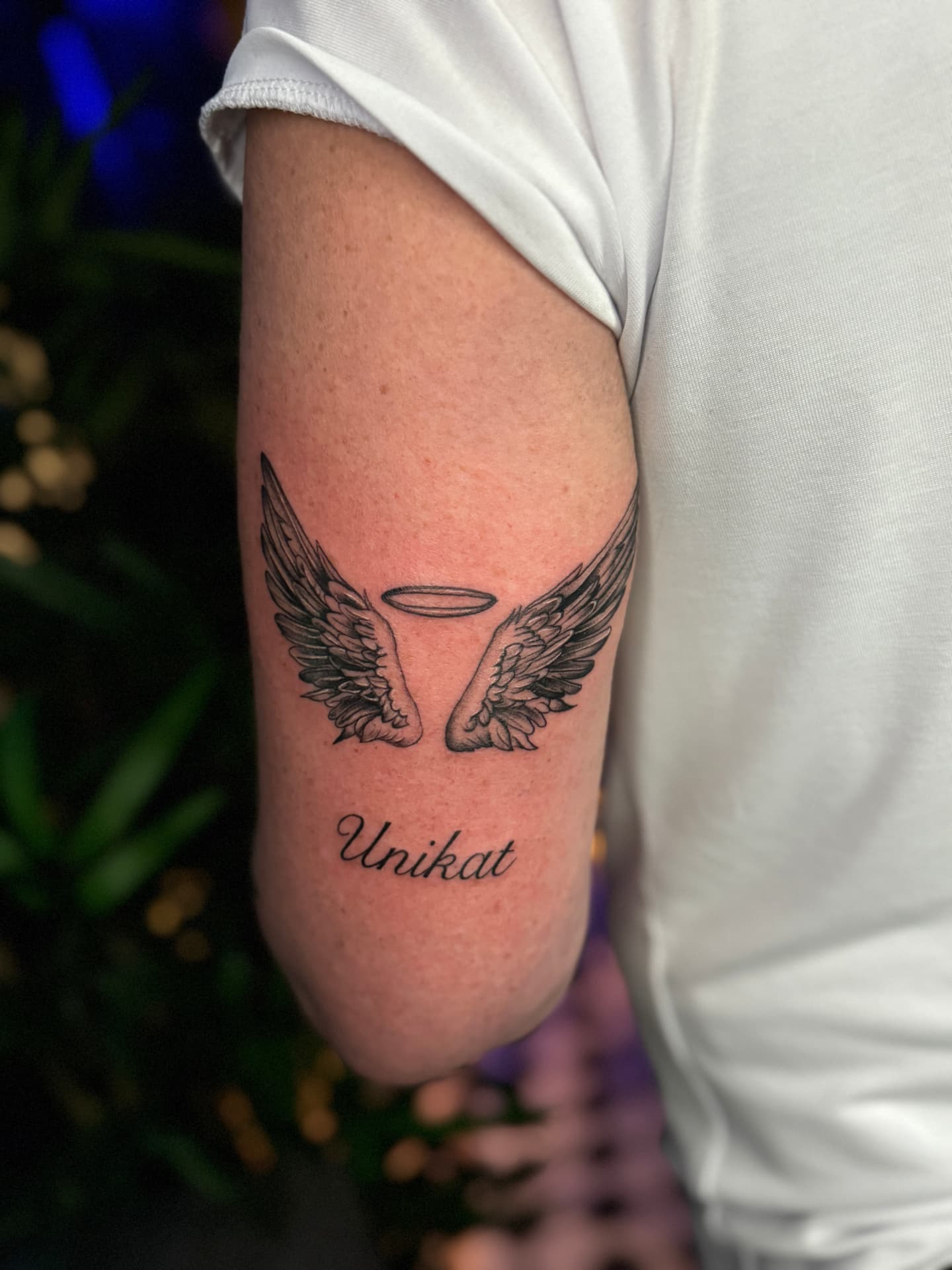 Engelsflügel mit Heiligenschein und Unikat-Lettering am Oberarm