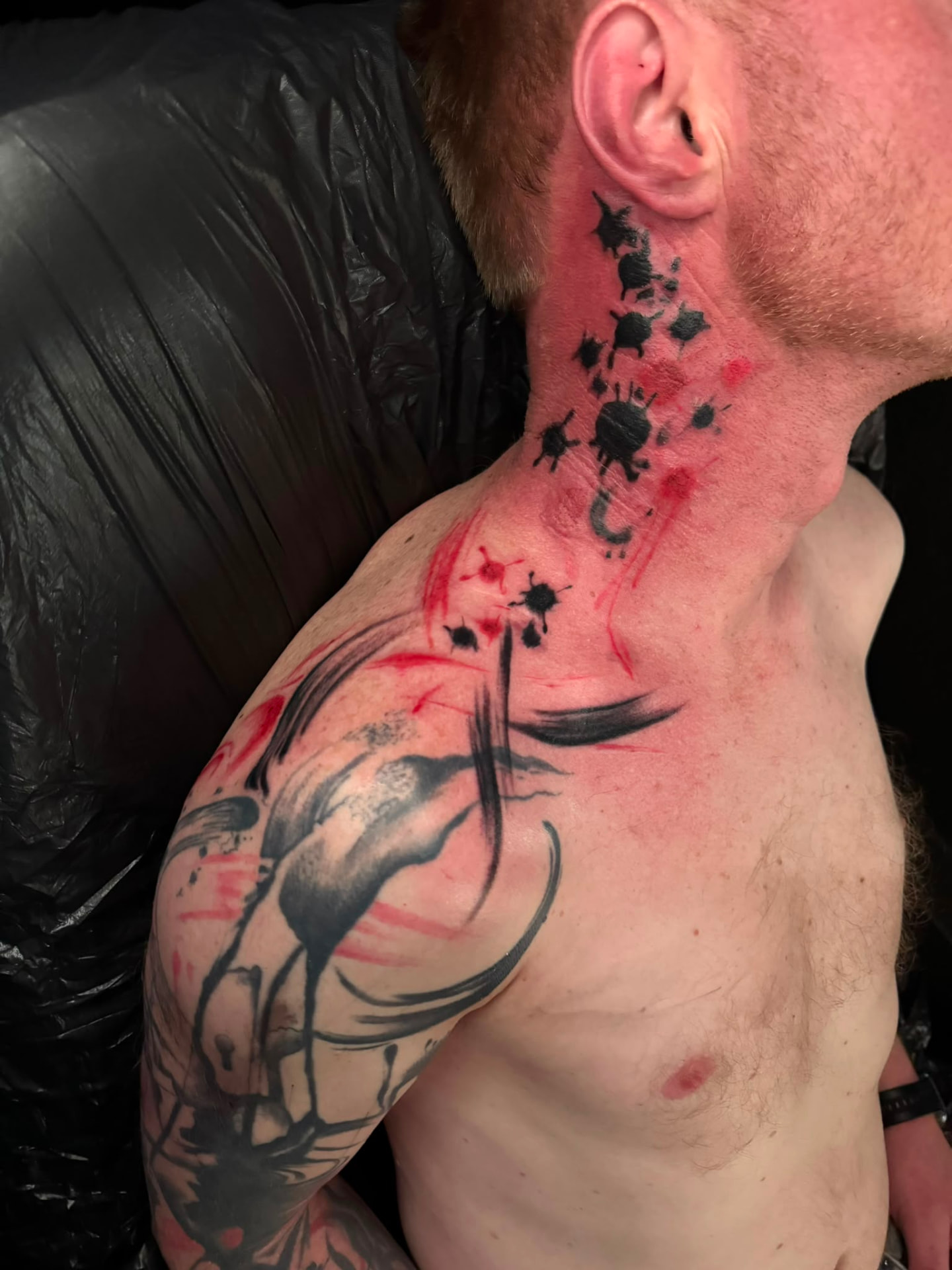 Black & Red Watercolor Tattoo an Hals und Schulter