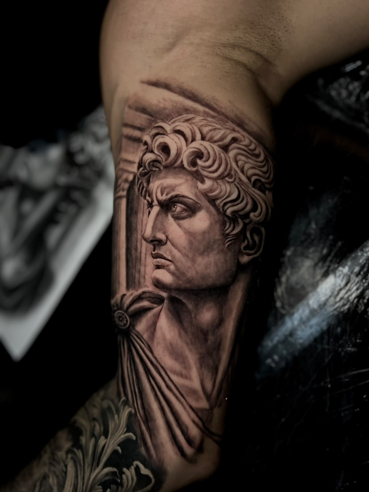 Antike Statue mit Säule am Oberarm, fotorealistisches Black & Grey von Tristan