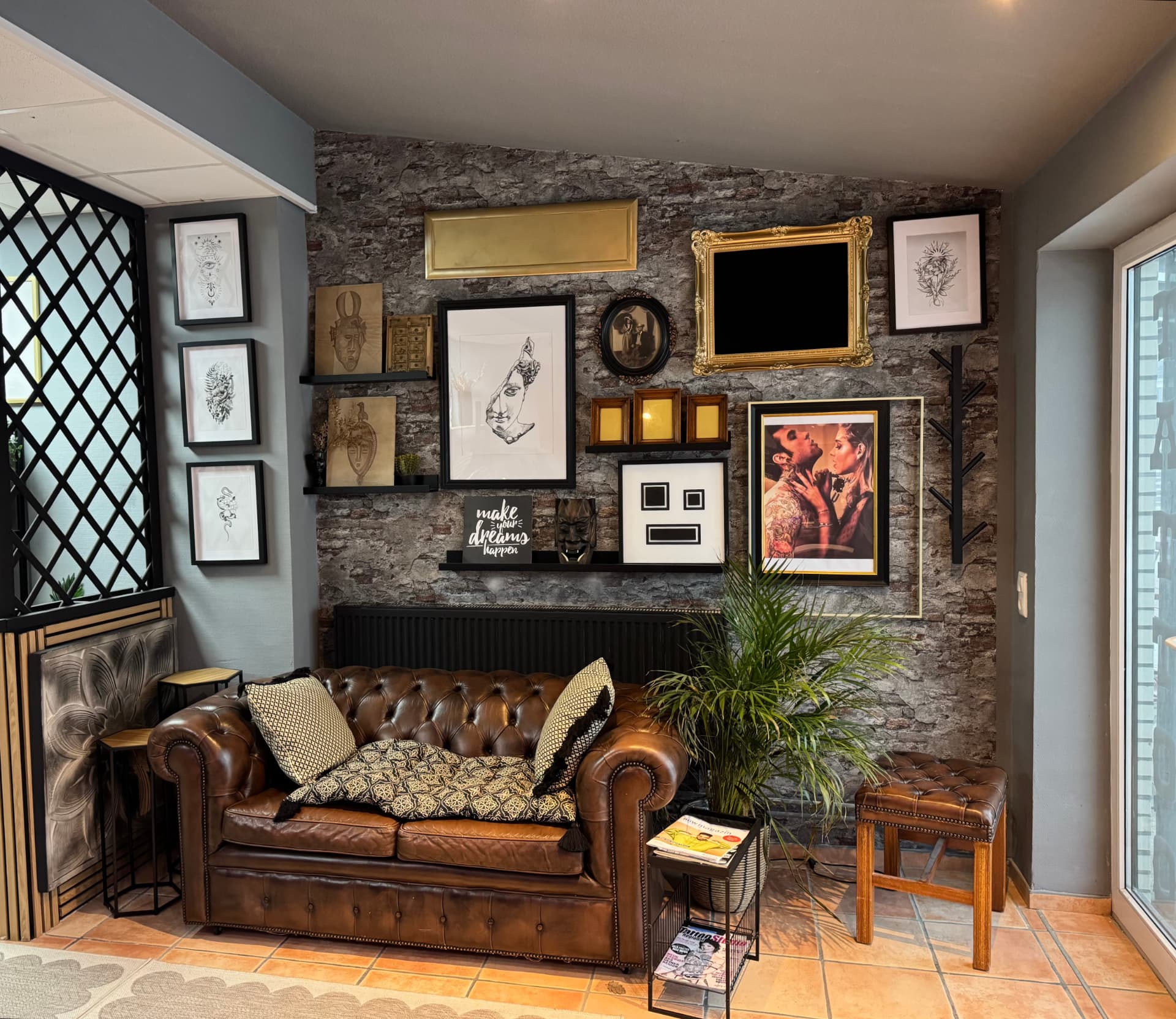 Lounge des Diamond Tattoo Studios mit Chesterfield-Sofa und Kunstwand