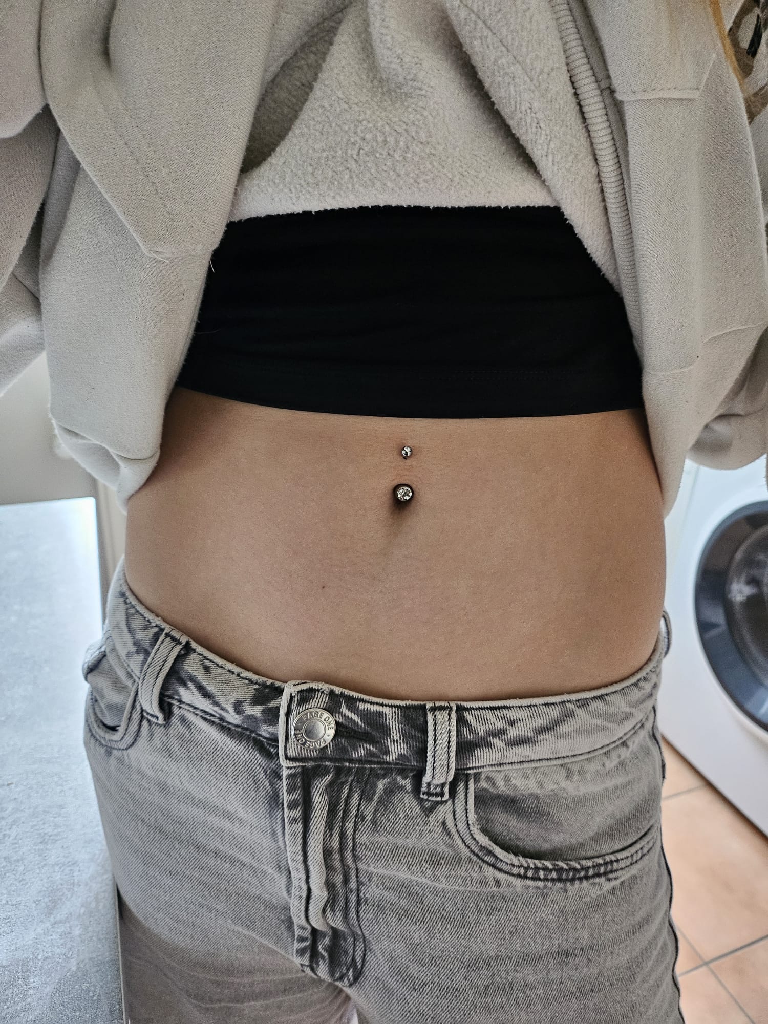 Frisch gestochenes Bauchnabel-Piercing mit doppeltem Kristall von Tati