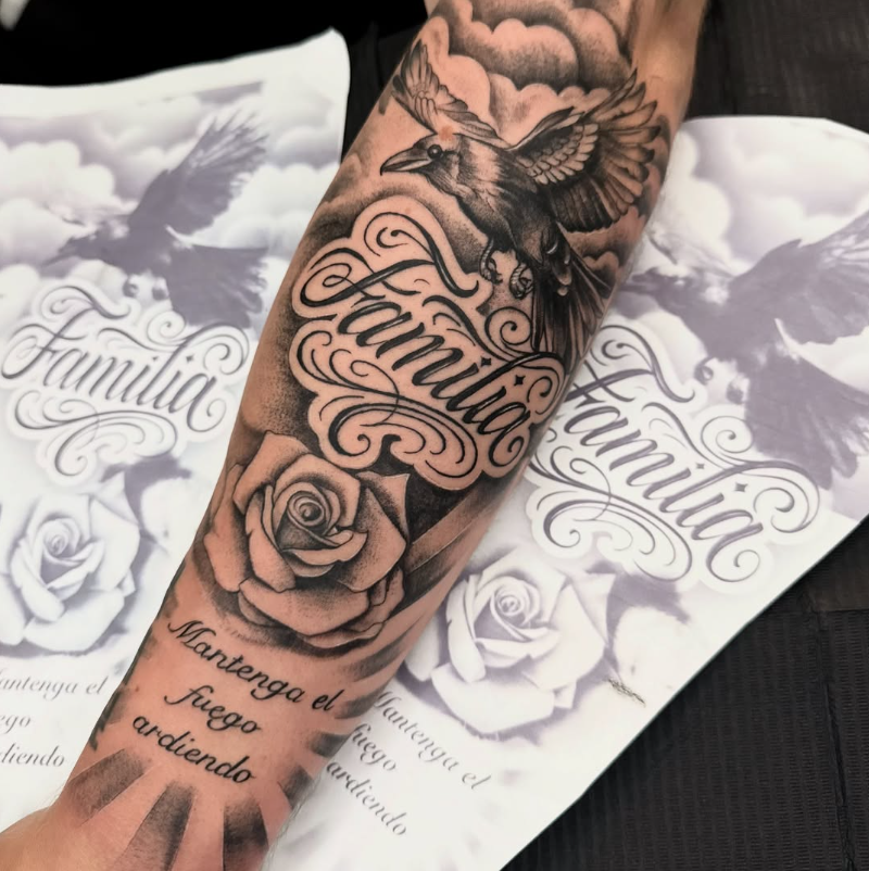 Chicano Lettering Familia mit Rose und Krähe am Unterarm