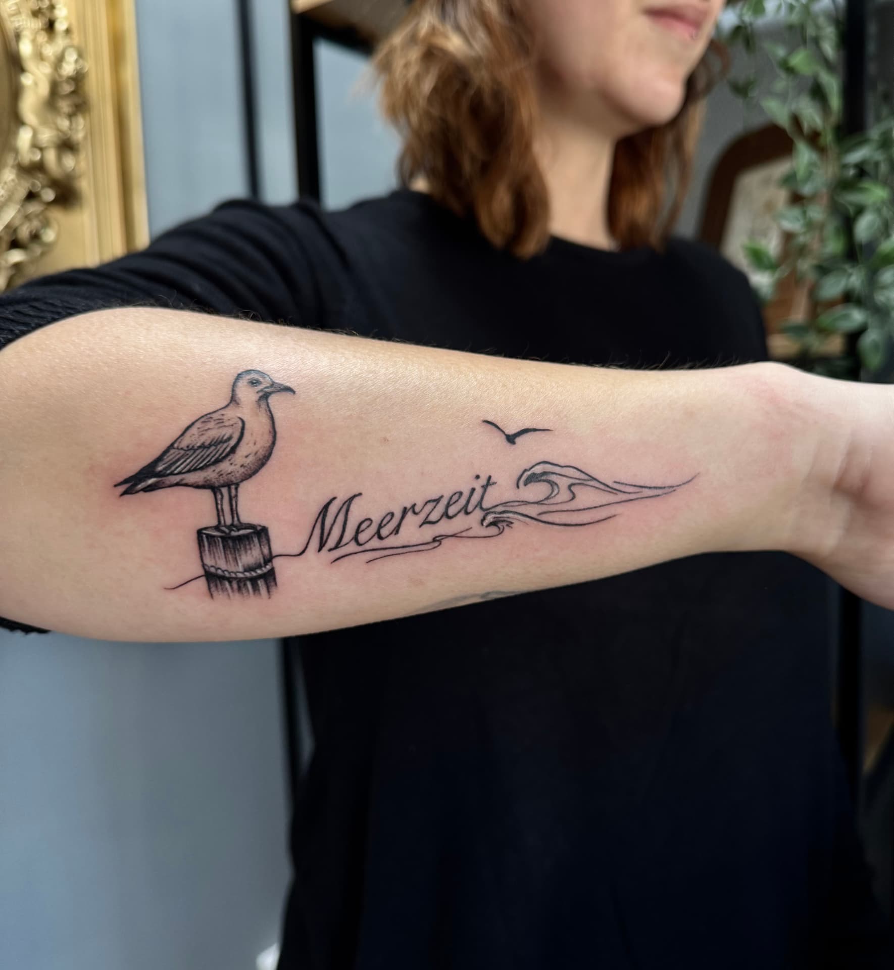 Möwe auf Dalben mit Schriftzug Meerzeit und Welle am Unterarm
