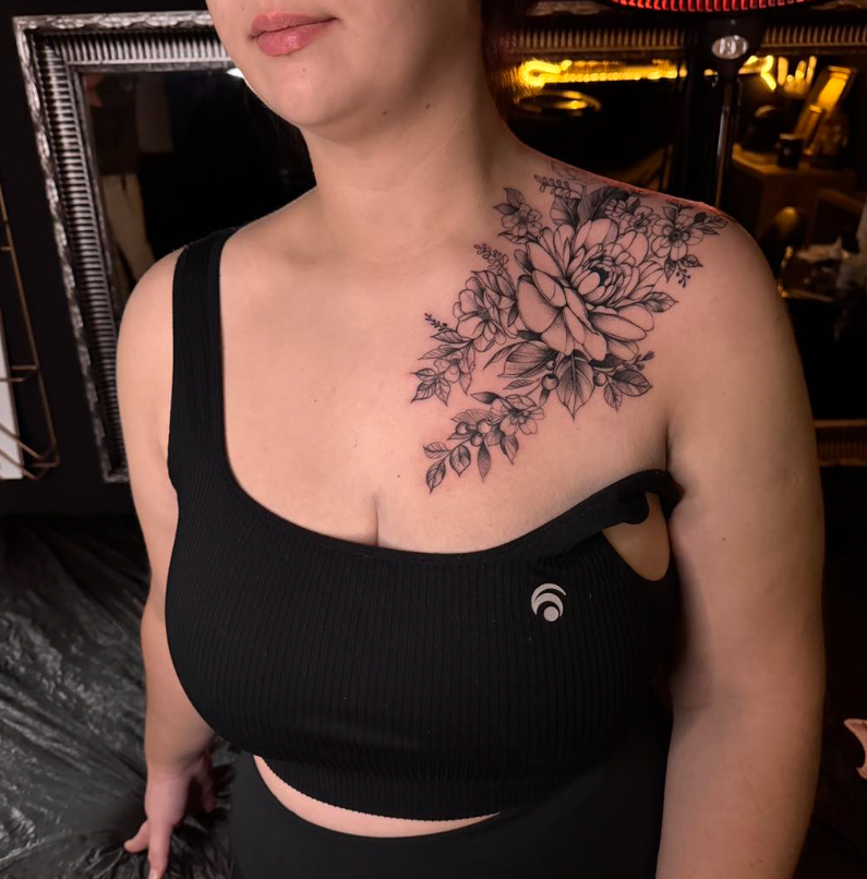 Florales Fineline Tattoo über Schulter und Dekolleté