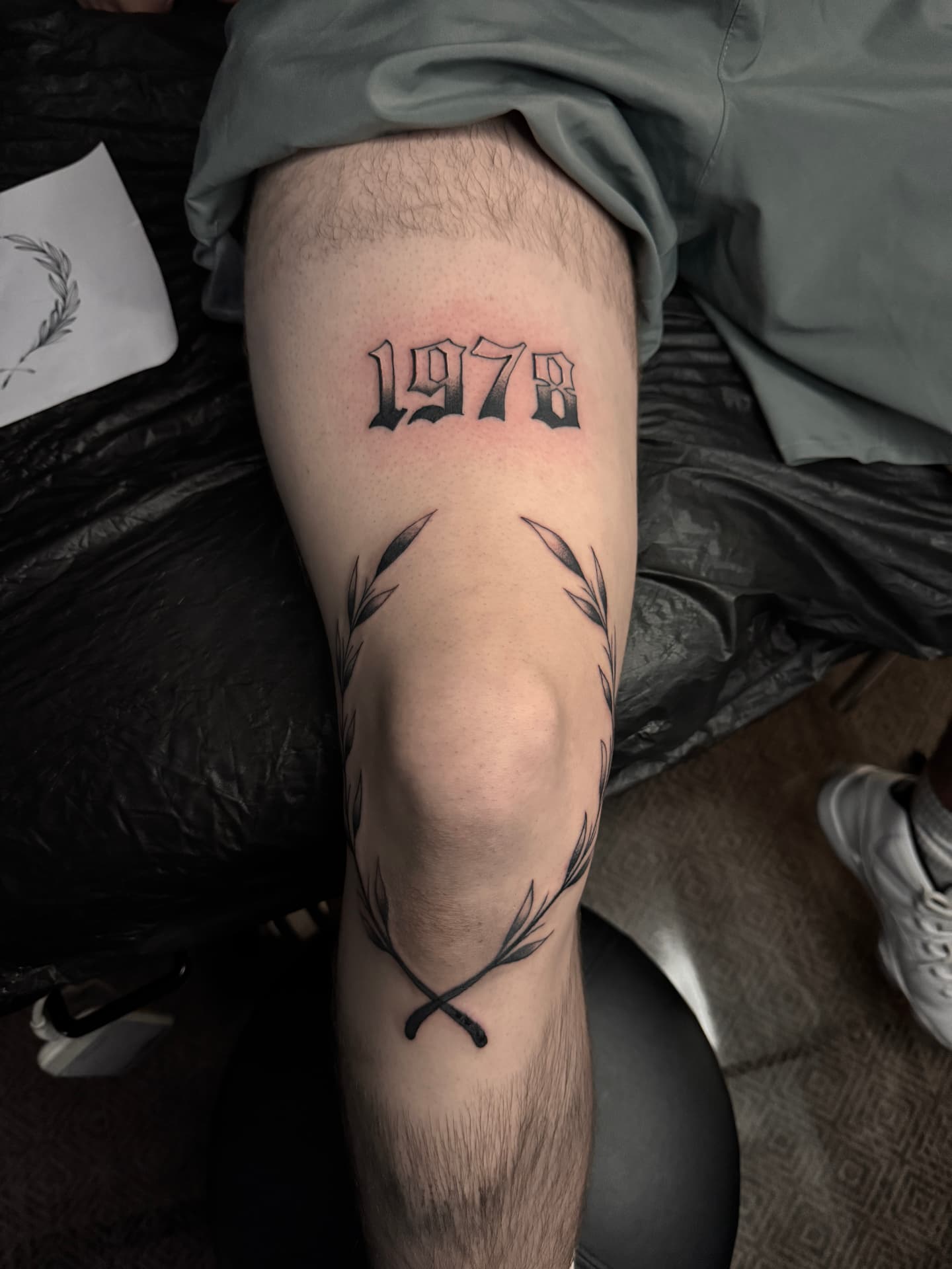 Jahreszahl 1978 in Blackletter mit Lorbeerkranz am Knie