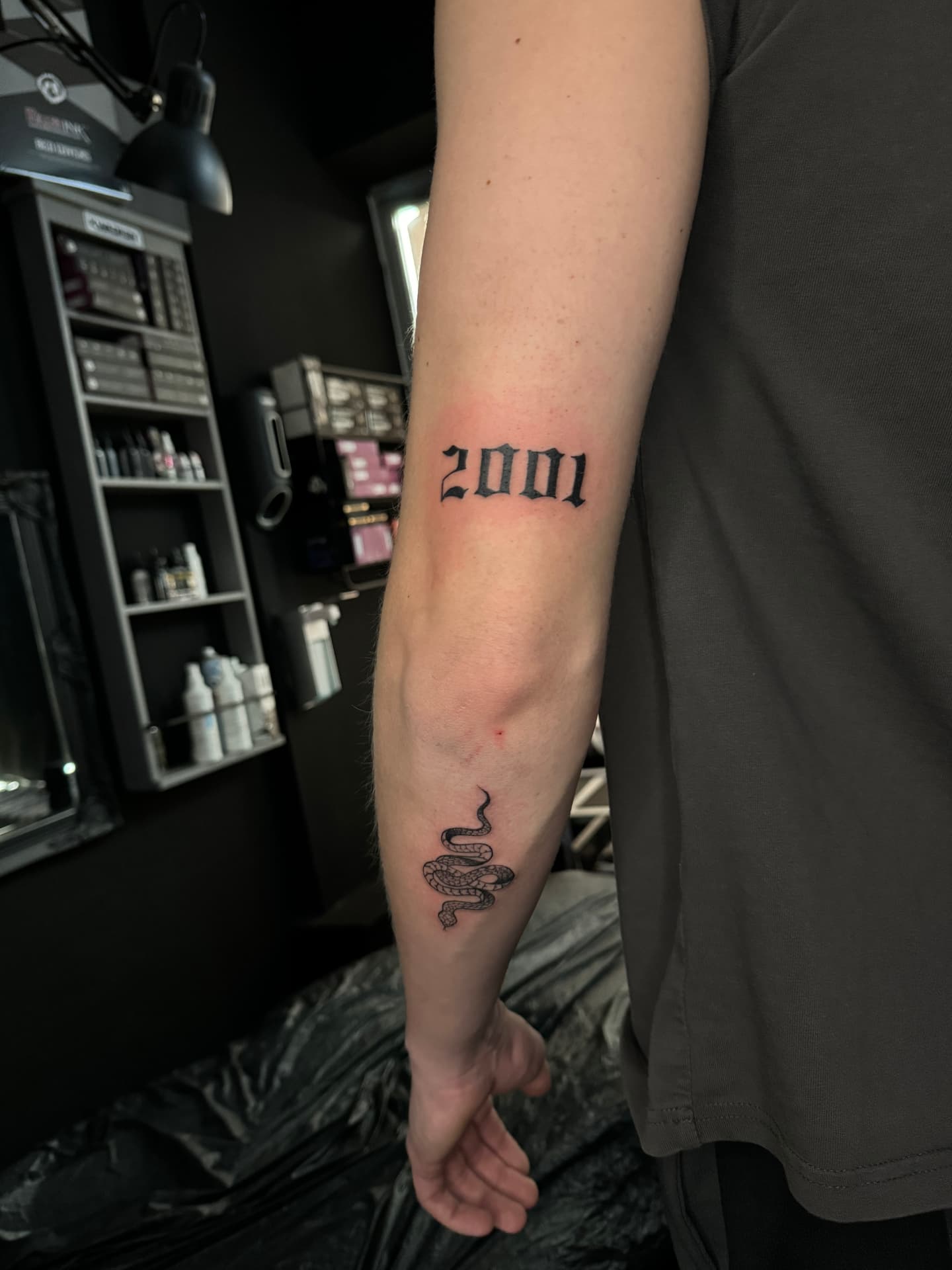 Jahreszahl 2001 in Blackletter mit kleiner Fineline-Schlange am Unterarm